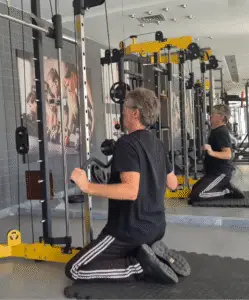 Showing a still image from my Kneeling Wide Lat Pulldown video - an exercise for the Back muscles - used alongside the Straight Arm Pulldown and Narrow Grip Pulldown