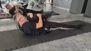 Showing a still image from my Single Knee Hug video - a Pilates exercise